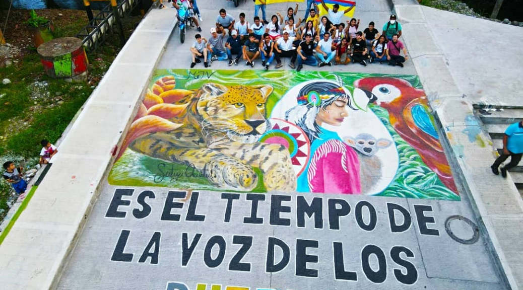 Photo of a street mural with nature themes reading, in Spanish, "This is the Time of the voice of the Communities"