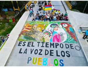 Photo of a street mural with nature themes reading, in Spanish, "This is the Time of the voice of the Communities"