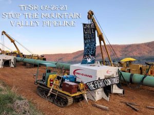 Banners left on pipeline construction equipment, reading "Where Will You Go When The Waters Rise?" and "The Fight Continues"