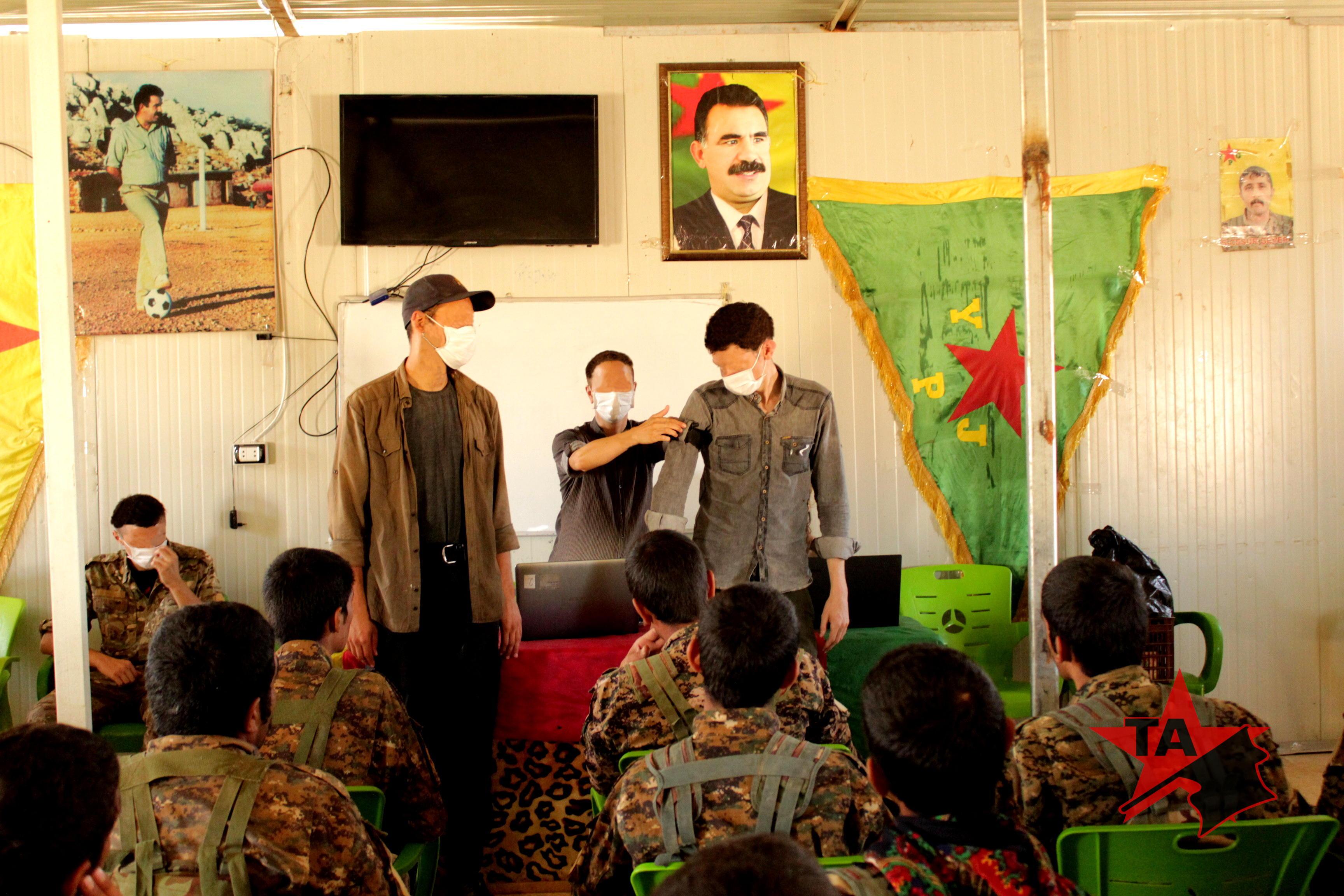 TA members educating YPG members on tourniquet use