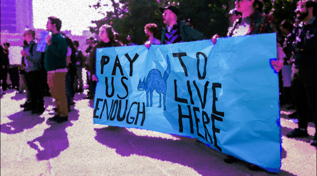 image of people at a rally at UC Berkeley in 2020 holding a sign reading "Pay Us Enough To Live Here" with a sabo-cat image (original pic by Jintak Han for DailyBruin.com