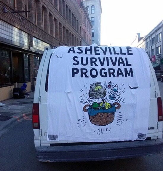 Van with "Asheville Survival Program" banner draped over the back from The Urban News paper from Asheville