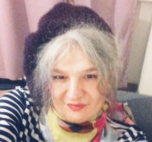 a photo of Eylem in a striped shirt with a beret and handkerchief around her neck